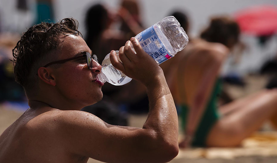 Un hombre bebe agua para refrescarse por el calor (EFE).